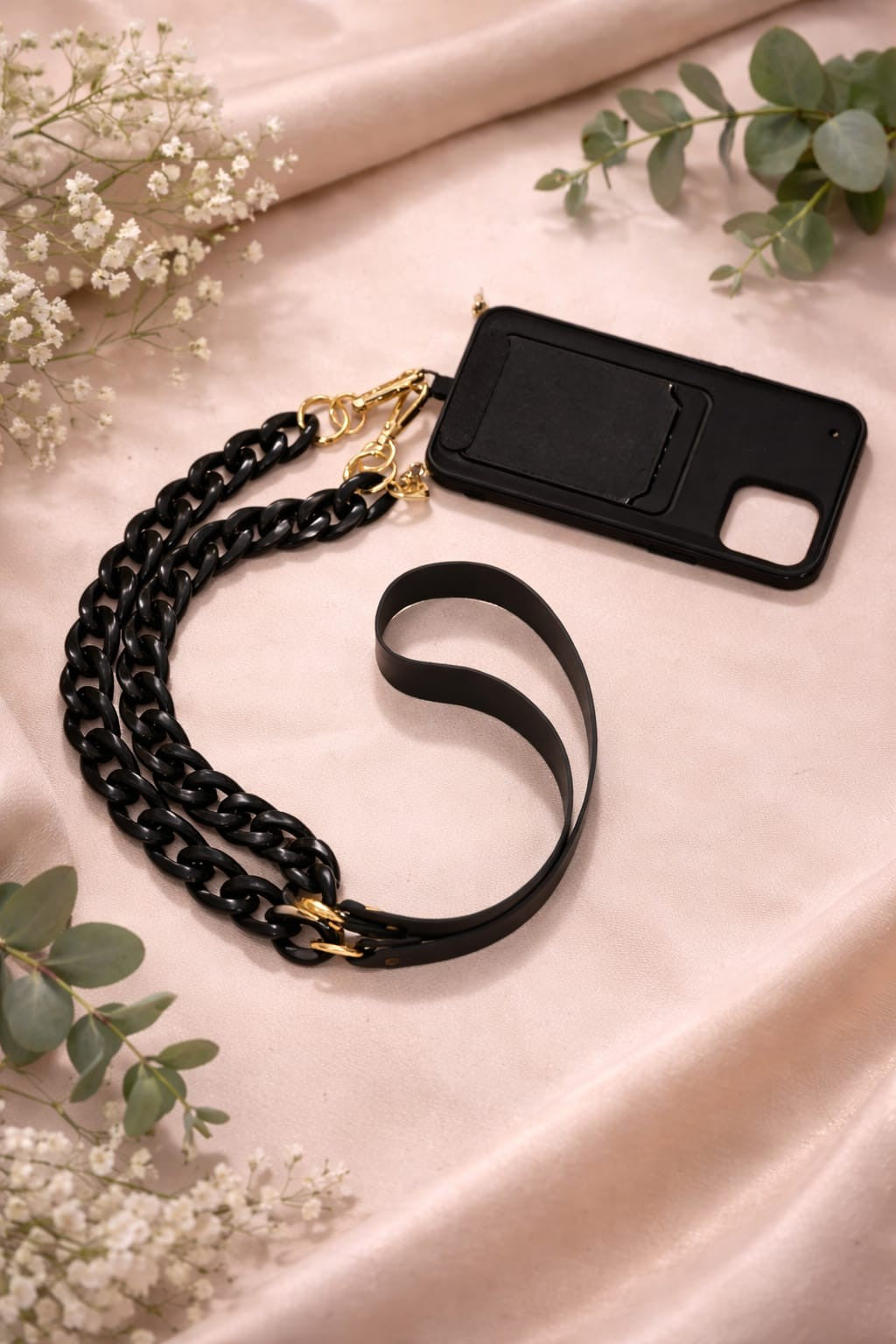 Black faux leather and acrylic crossbody phone chain displayed with a smartphone case.